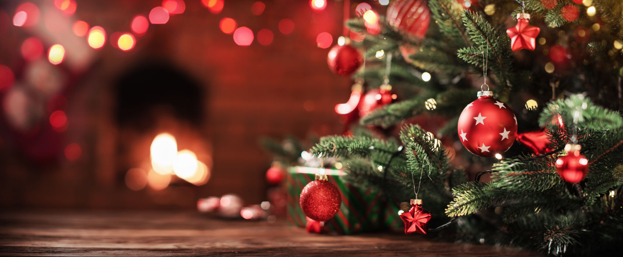Christmas Tree with Decorations Near a Fireplace with Lights