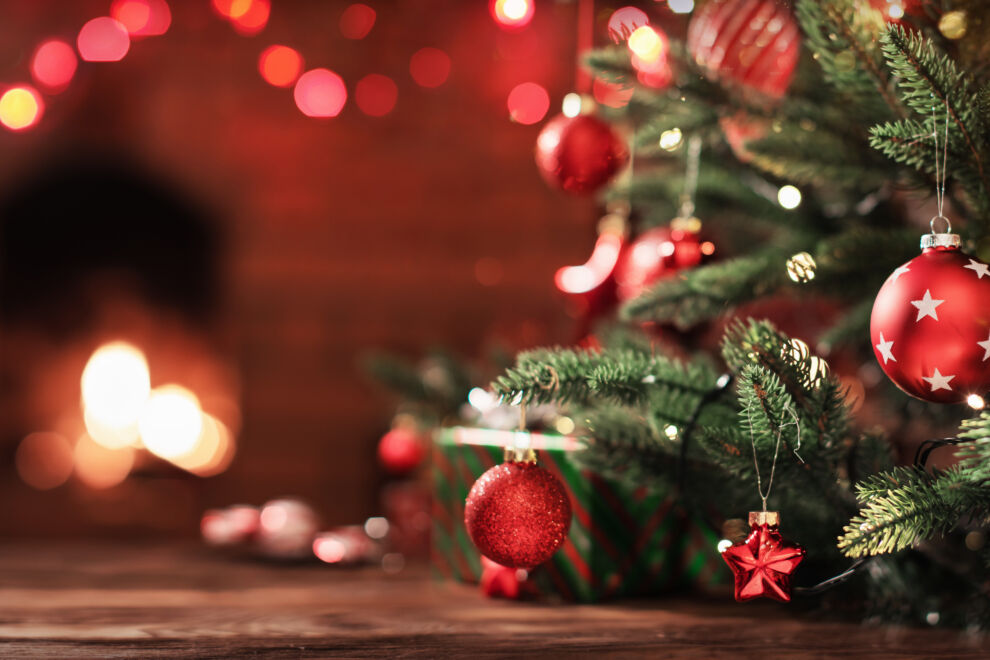 Christmas Tree with Decorations Near a Fireplace with Lights